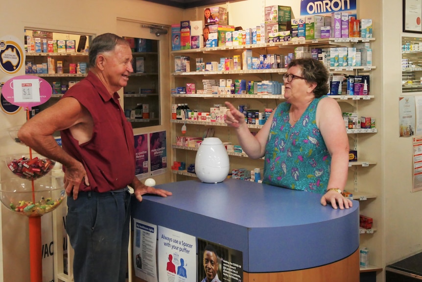 a woman speaking to someone at a pharmacy