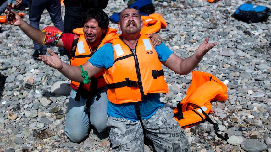 Refugees from Syria pray after arriving on the shores of the Greek island of Lesbos aboard an inflatable dinghy across the Aegean Sea from from Turkey