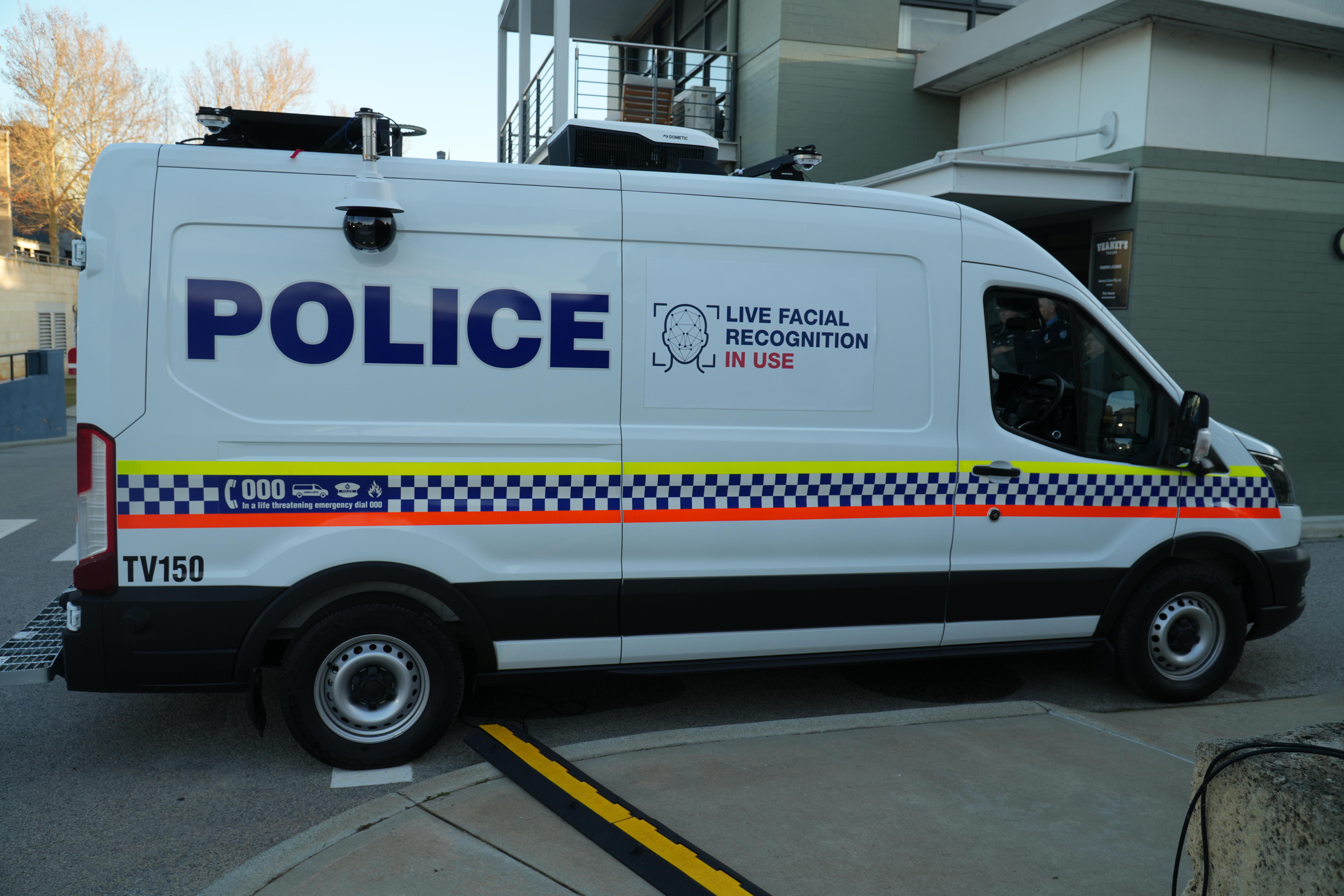 A white WA Police van with a sign on the side reading 'live facial recognition in use'.