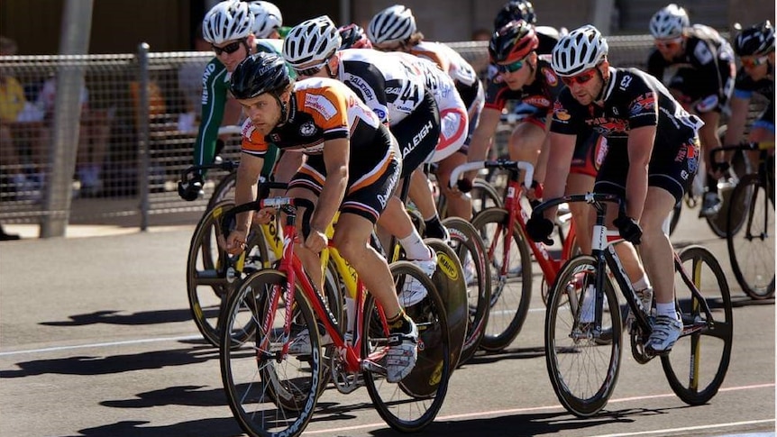 Ten cyclists wearing lycra jostle for first place in a velodrome race