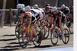 Ten cyclists wearing lycra jostle for first place in a velodrome race