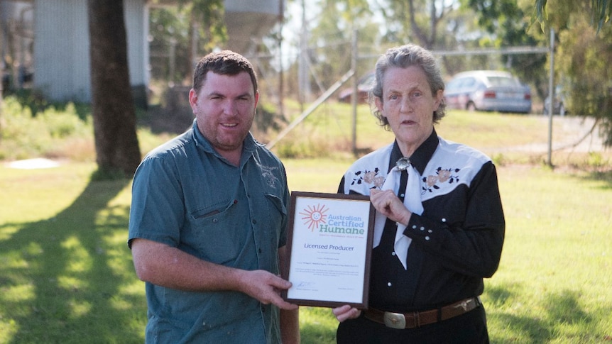 A woman handing a man a framed certificate