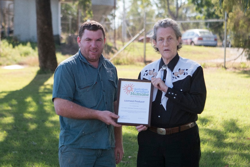 A woman handing a man a framed certificate