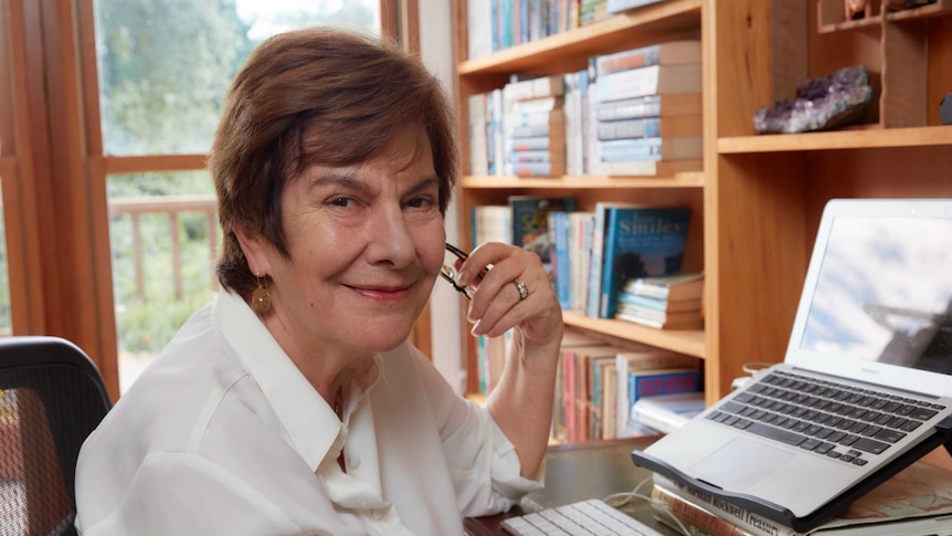 An older women sits in front of a laptop.