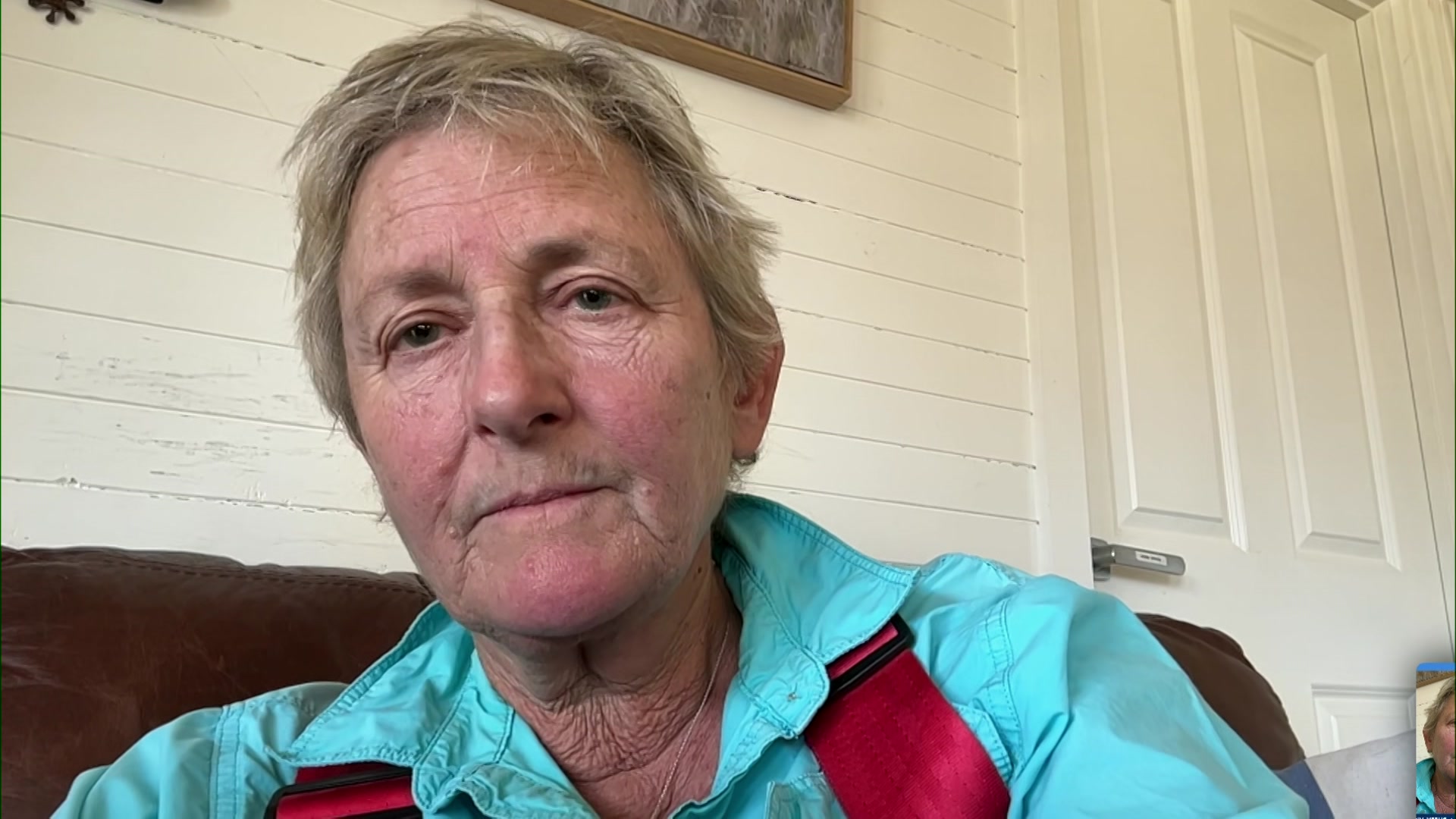 Felicity Sloman parece pensativa em uma sala durante a entrevista