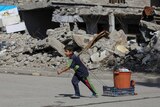 A boy pulls his belongings along a street in eastern Mosul