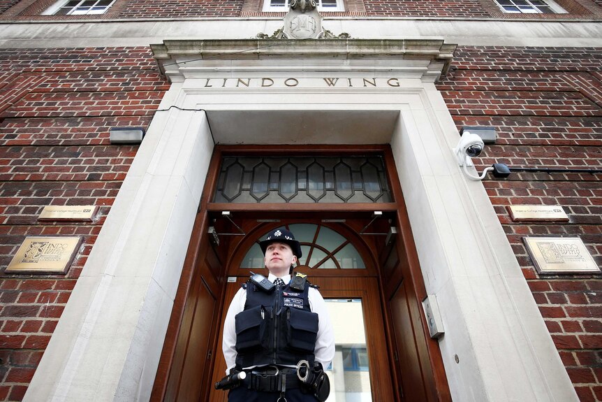 A police officer stands guard outside the Lindo Wing of St Mary's Hospital.