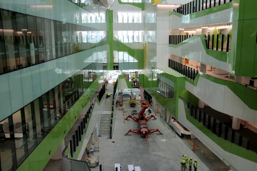 Looking down through internal atrium in Perth Children's Hospital with machinery and construction workers on the ground.