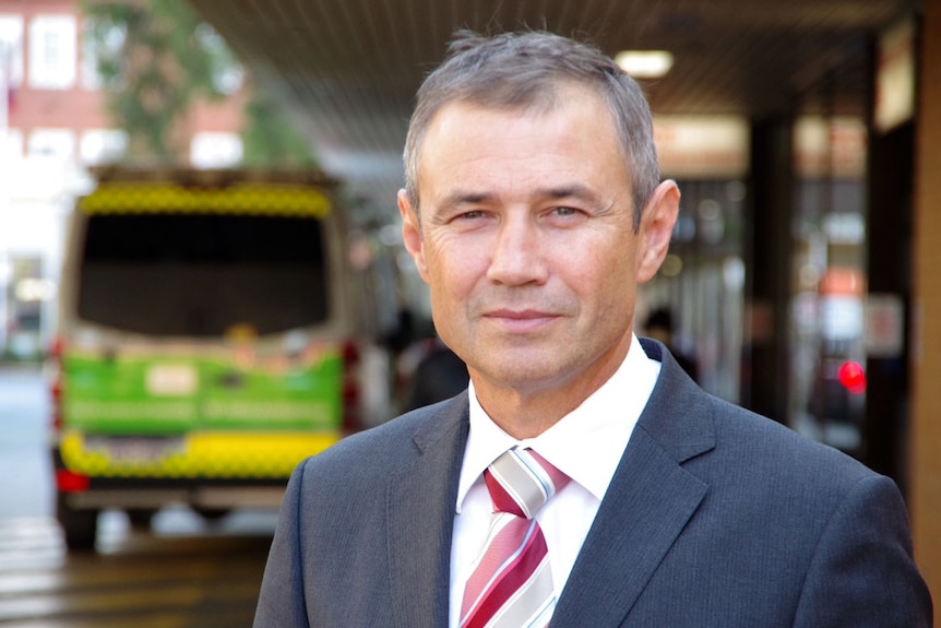 WA Labor health spokesman Roger Cook with ambulance in background