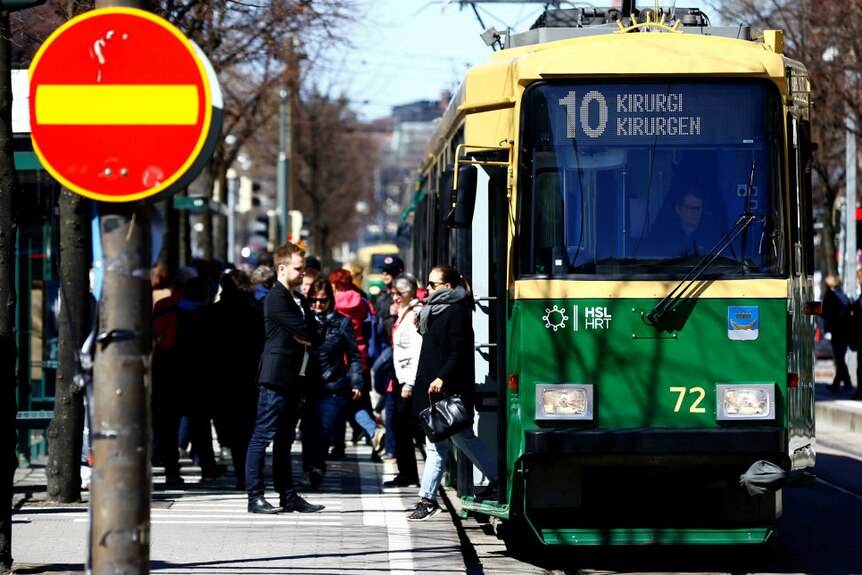 Finland people alight from tram in Helsinki