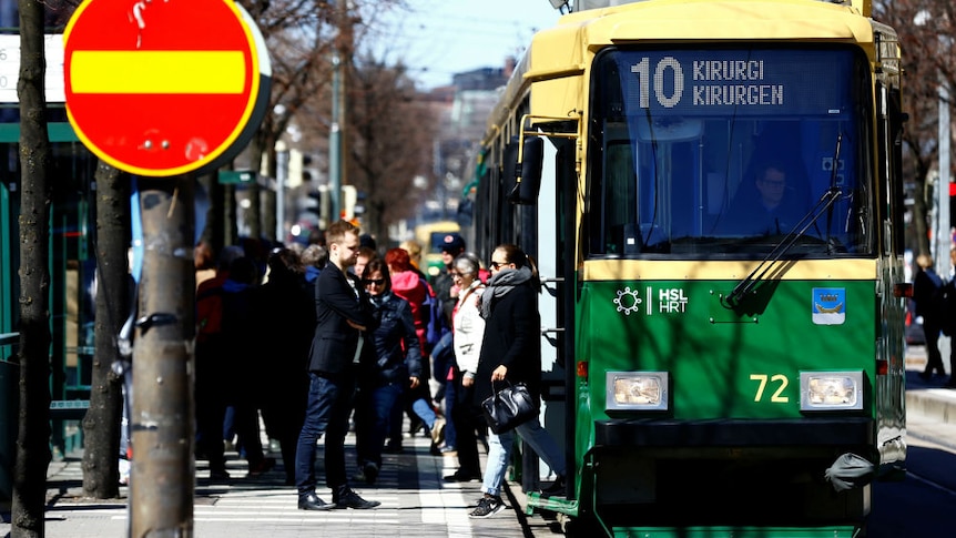 Finland people alight from tram in Helsinki