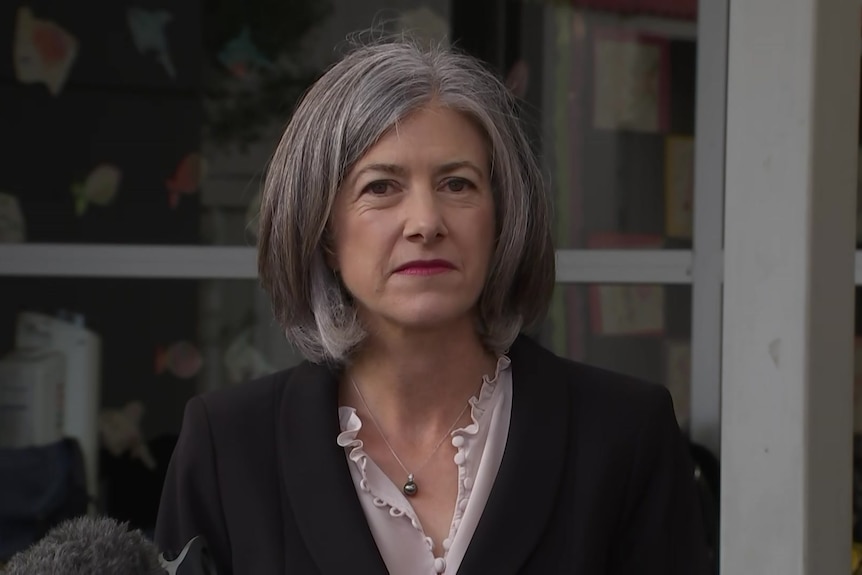 A woman with gray hair wearing a black top