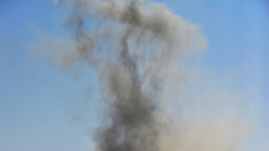 Libyan rebels defiantly raise their weapons after an airforce fighter jet dropped a bomb near Ras Lanuf