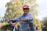 Woman wearing a helmet sits on a bike 