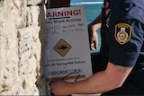 A ranger sets up a beach closed sign after a shark attack.