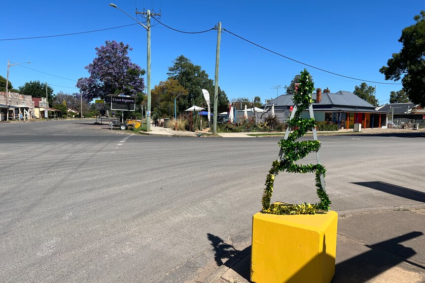 A tinsel Christmas tree sits on the side of a road.