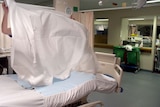 nurse makes a bed in a hospital ward