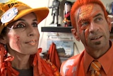 woman and man in orange clothes and orange glitter on their face