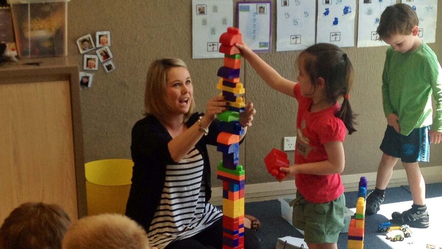 University of Tasmania lecturer Coleen Cheek helps a child at the early learning centre in Burnie.