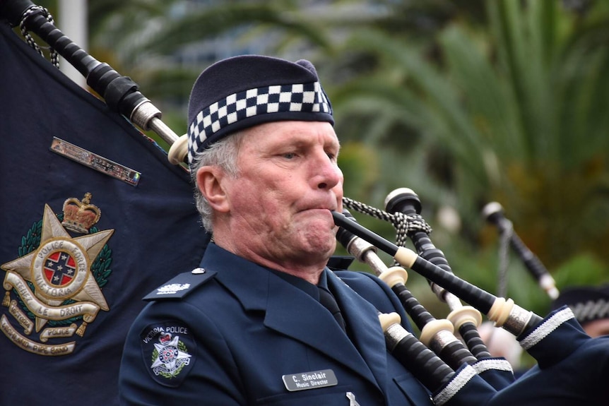 A man plays bagpipes during the Anzac Day march in Melbourne
