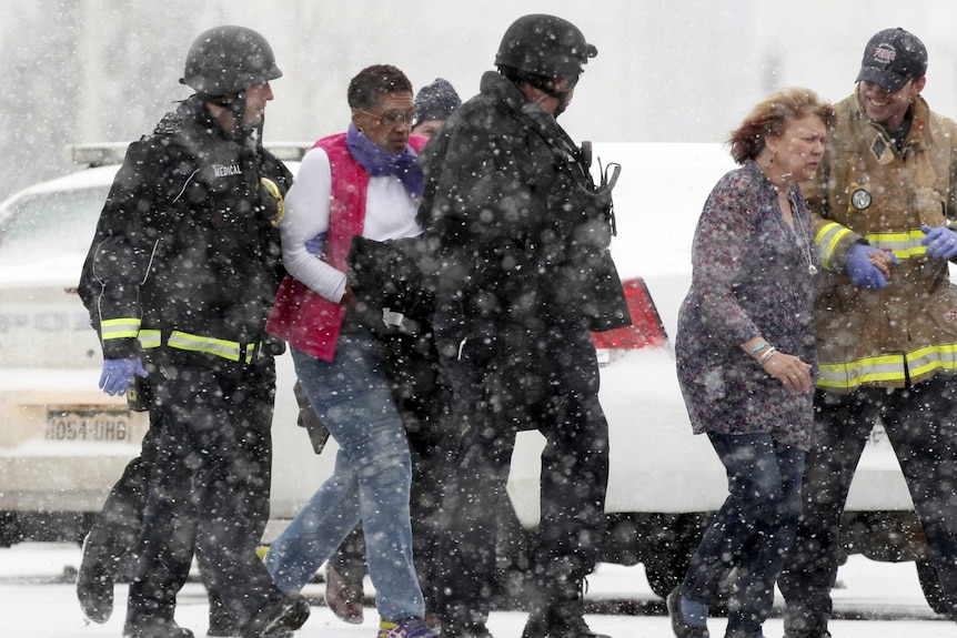 Two women are evacuated from a building where a shooter was suspected to be still holed up in Colorado Springs, Colorado, November 27, 2015