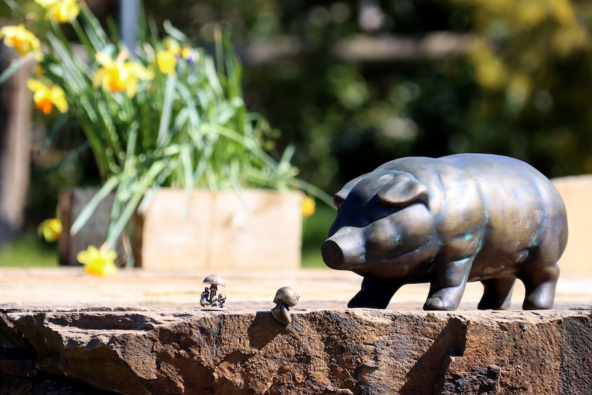 A small bronze sculpture of a pig.