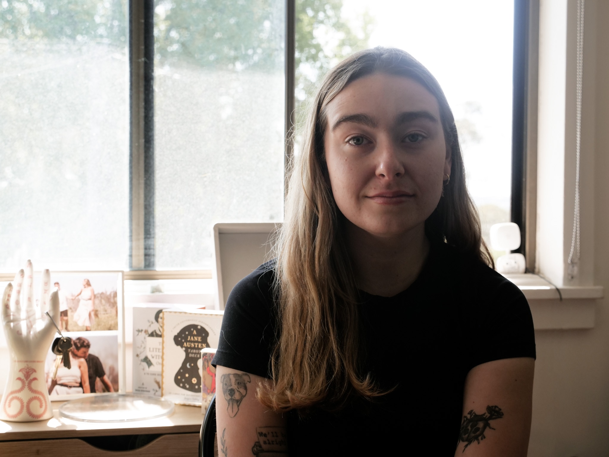 Woman smiles weakly at the camera. 