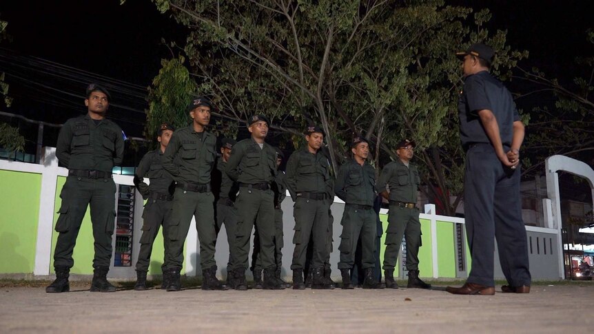 A superior officer briefs the officers before they head out.