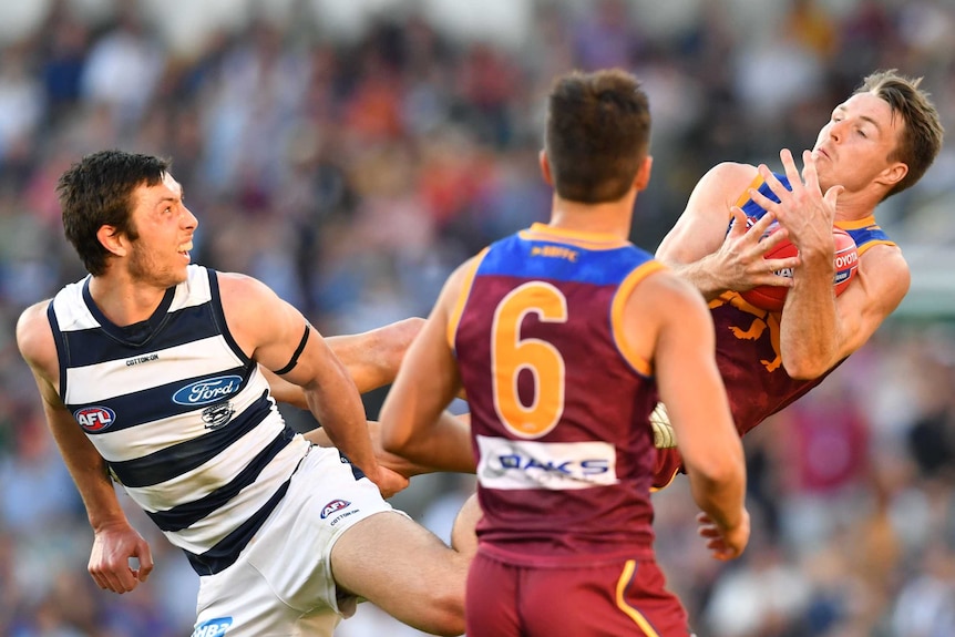 Lincoln McCarthy takes a mark while high off the ground with his knees in Jack Henry's back. Hugh McCluggage impedes our view.