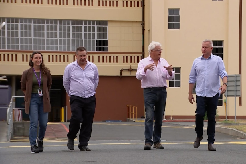 Jeremy Rockliff and Simon Currant walk together outside the Cadbury factory with two other people
