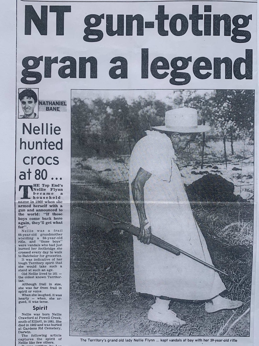 Photo of a newspaper page featuring black and white photo of short elderly woman holding a shotgun