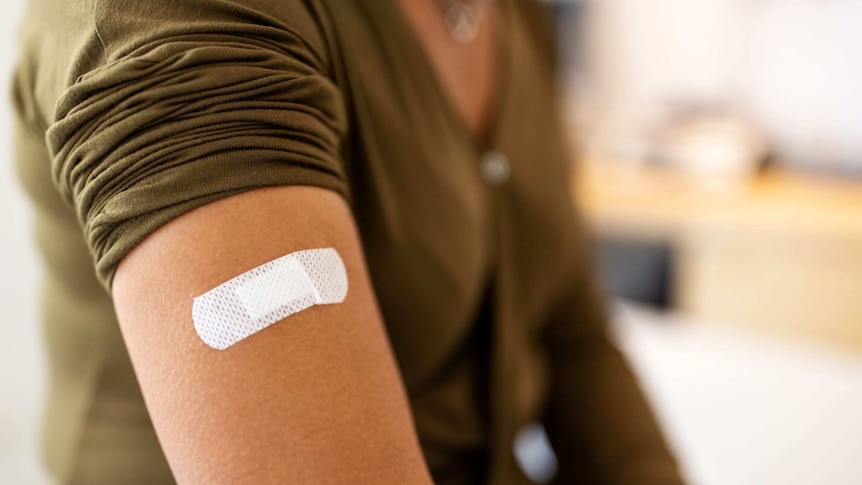 Band aid on woman's arm after vaccination