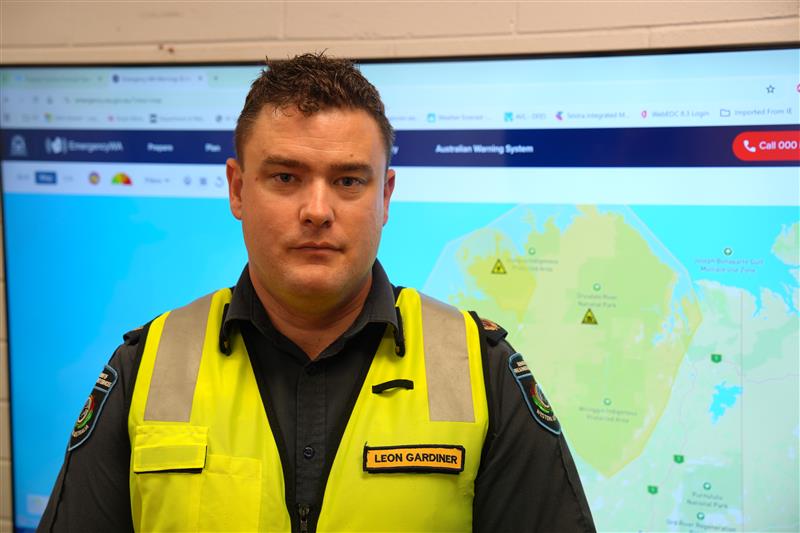 A man wearing a high-visibility vest and looking at the camera