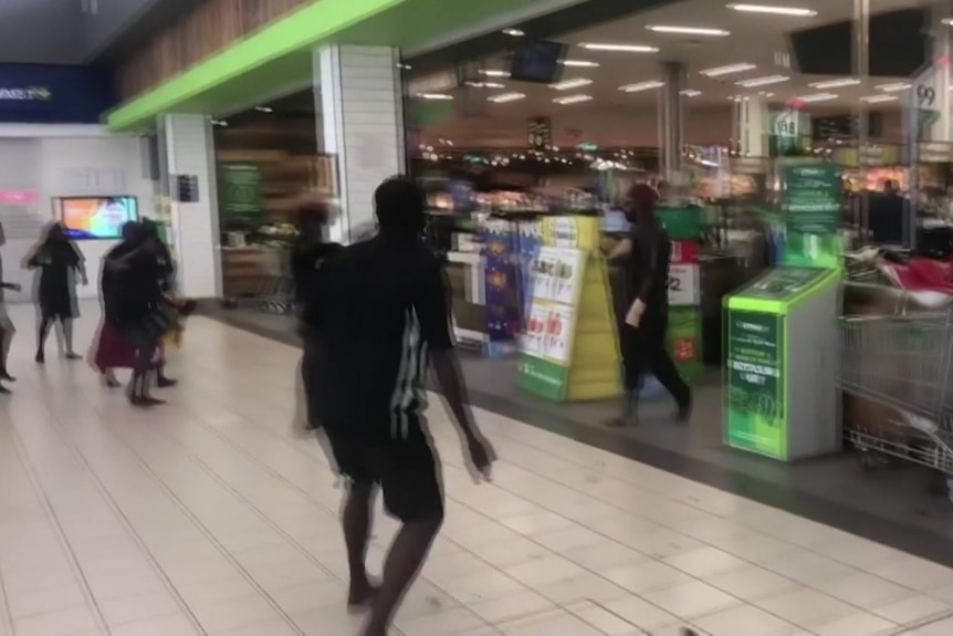 Footage of multiple people running through the Darwin CBD Woolworths.