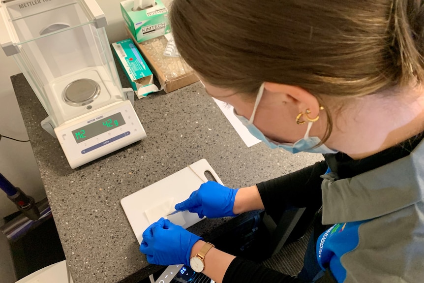 a healthworker inspecting a substance in a labratory 