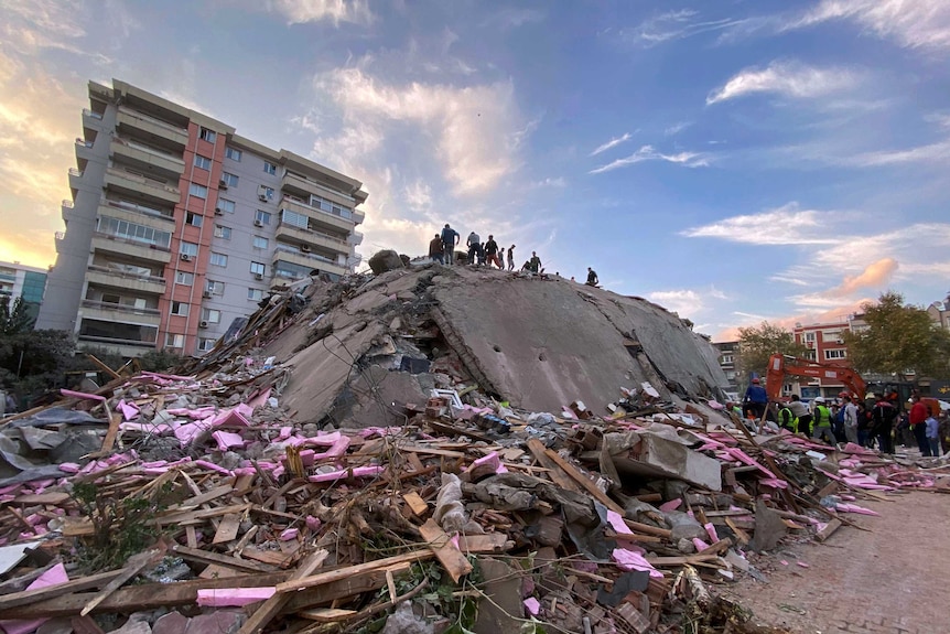 Rescue workers try to save people trapped in the debris of a collapsed building in Izmir.