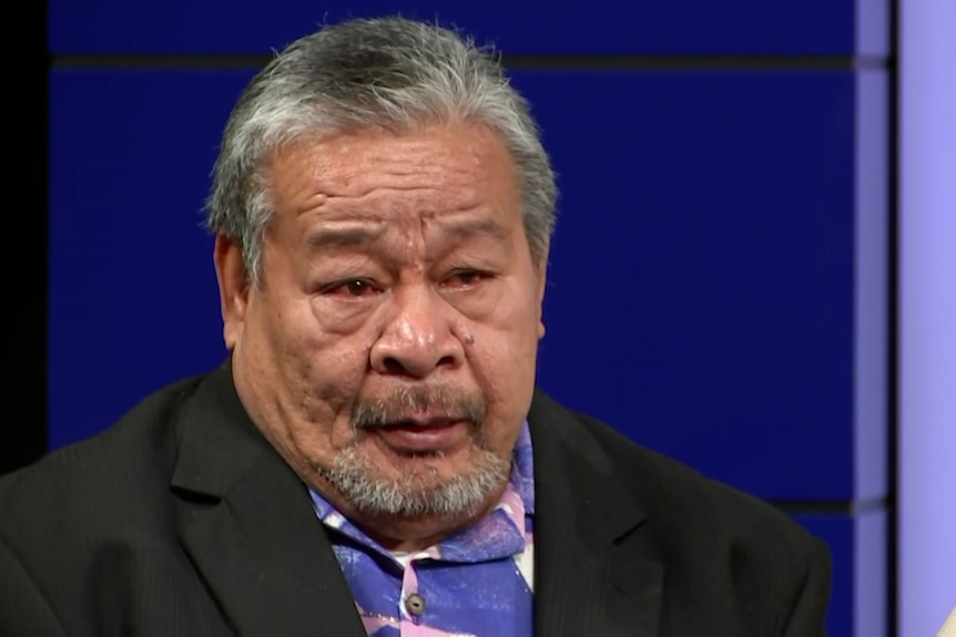 An elderly man at a police press conference.