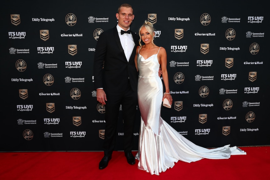 A Many Sea Eagles NRL player stands with his partner on the red carpet at the Dally M Awards.