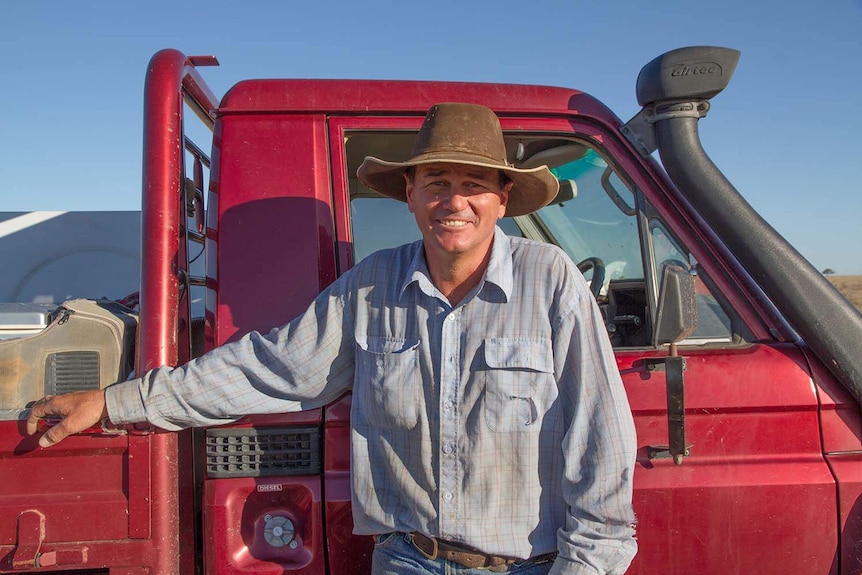 Grazier PJ Elliott stands beside a red 4WD vehicle at his property Corfield, north of Winton, in western Queensland.