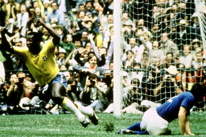 An old photo of a man in a yellow jersey jumping with his arms raised