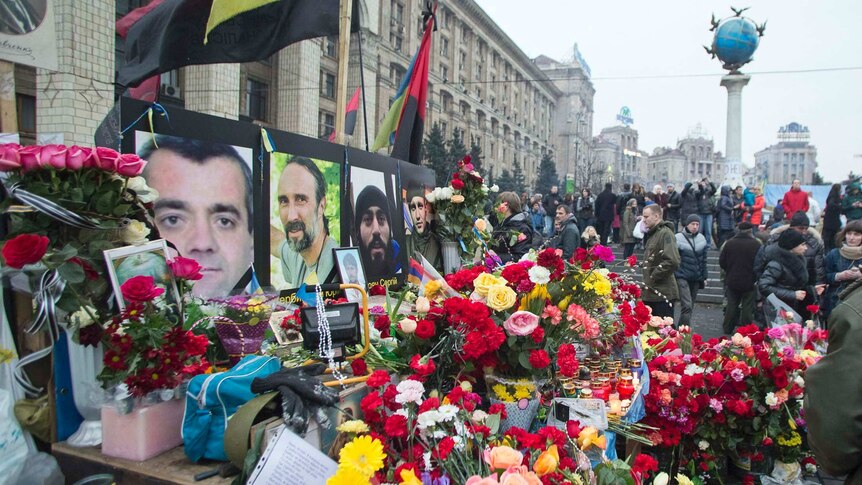 Mourners place flowers at memorial in Kiev