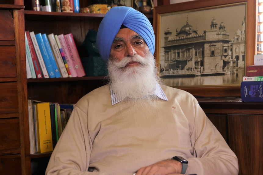 A mid shot of Jatinderpal Singh sitting in front of a bookshelf