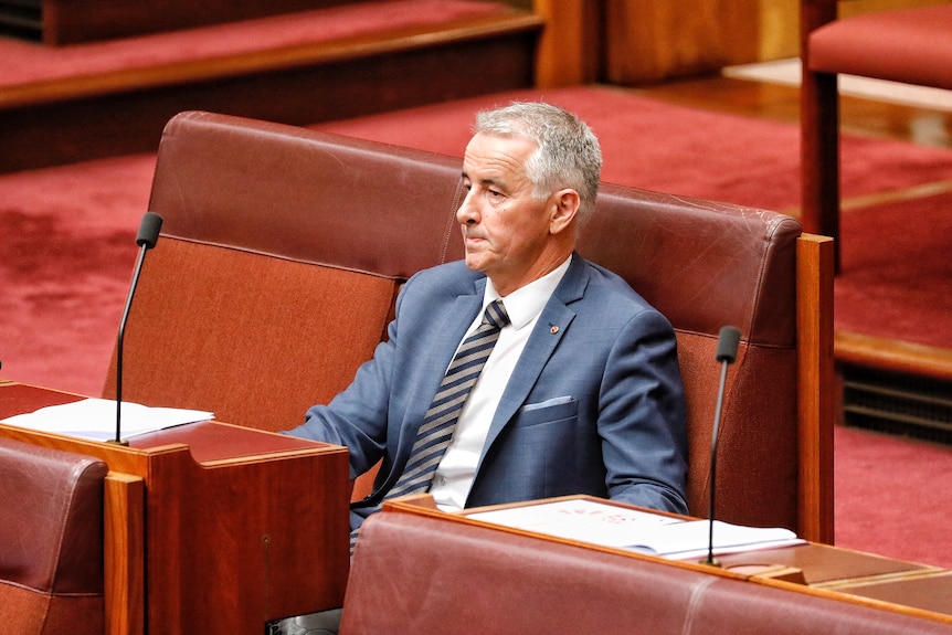 Gerard Rennick sits on the backbench in the Senate looking into the distance.