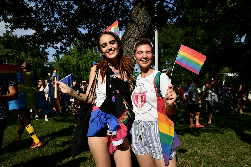 Participants pose with rainbow flags during a gay pride parade in Budapest