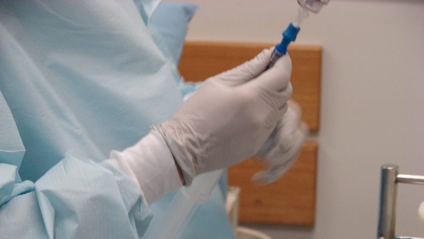 A nurse preparing a drip in hospital.