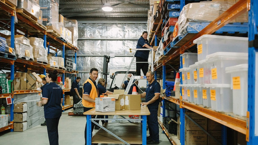People working in a warehouse with boxes