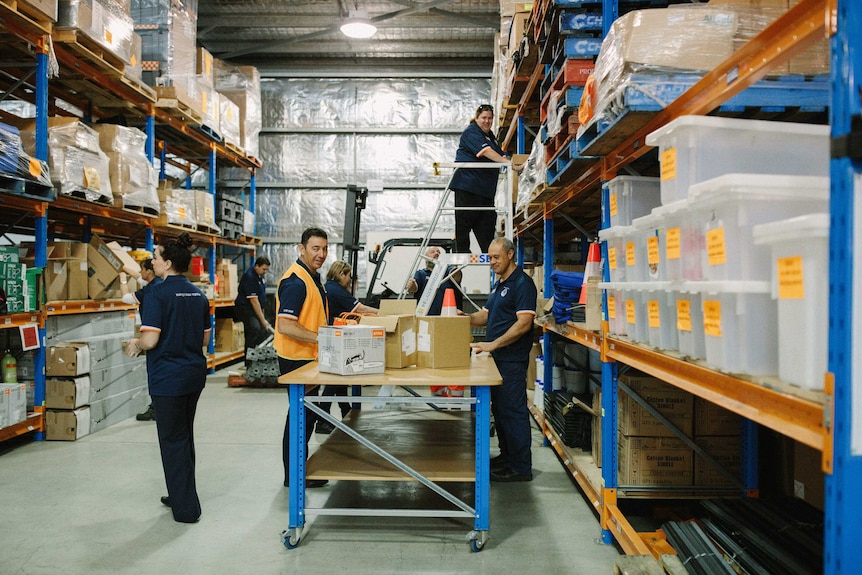 People working in a warehouse with boxes