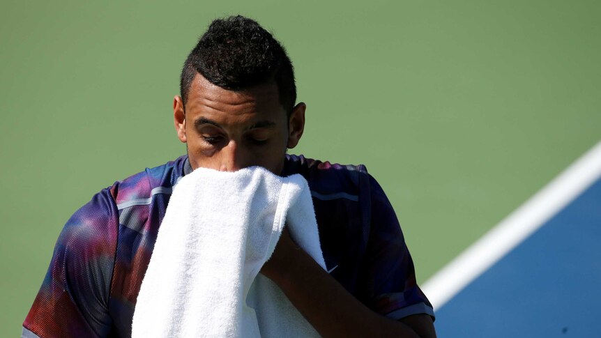 Nick Kyrgios wipes his face with a towel after a point against John Millman at the 2017 US Open.