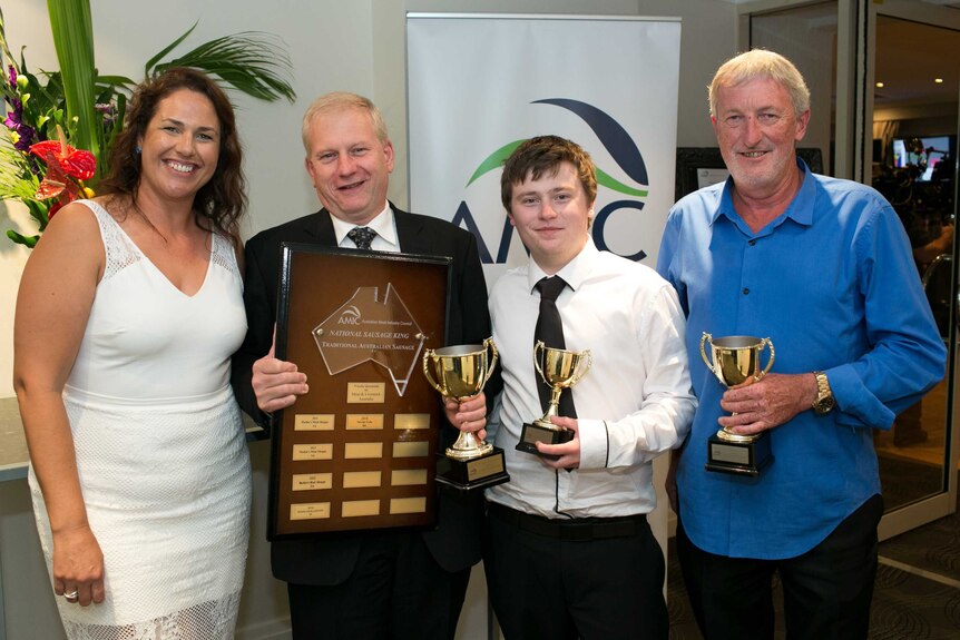 Sausage King Franz Knoll stands alongside other winners clutching his plaque and trophy