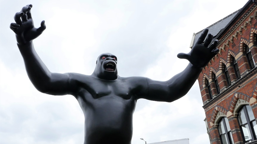 A giant King Kong statue with arms outstretched, looking menacing